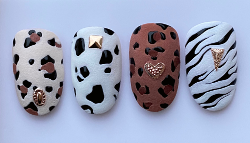 Elegáns fekete-fehér indás minták és gyöngyös részletek teszik ezt a körömdizájnt kifinomulttá és modernné